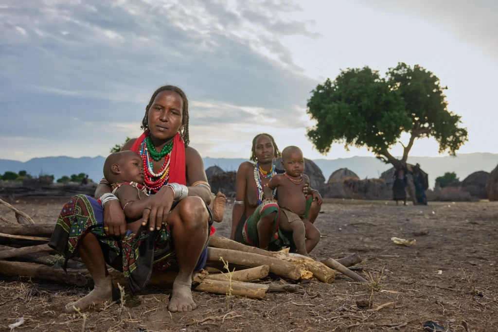 Arbore women with children sitting under tree near huts in tribal Ethiopia | Michaela Pupíková Photography
