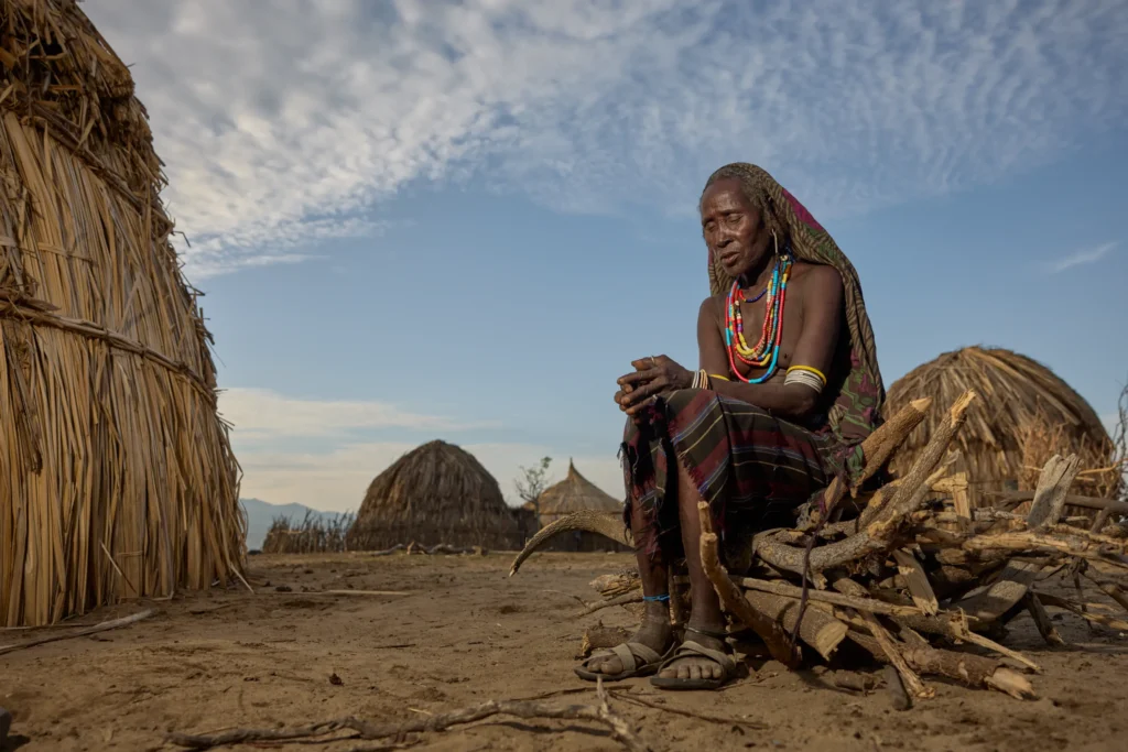 Arbore elder sitting alone in traditional village at sunset, Ethiopia | Michaela Pupíková Photography
