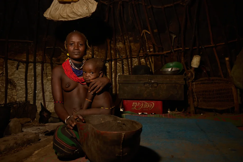 Dassanech woman with child sitting inside hut in southern Ethiopia | Michaela Pupíková Photography