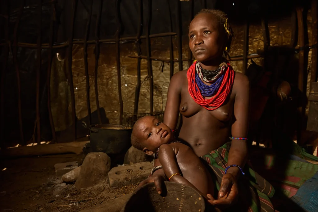 Dassanech mother with nursing child inside traditional hut in Ethiopia | Michaela Pupíková Photography