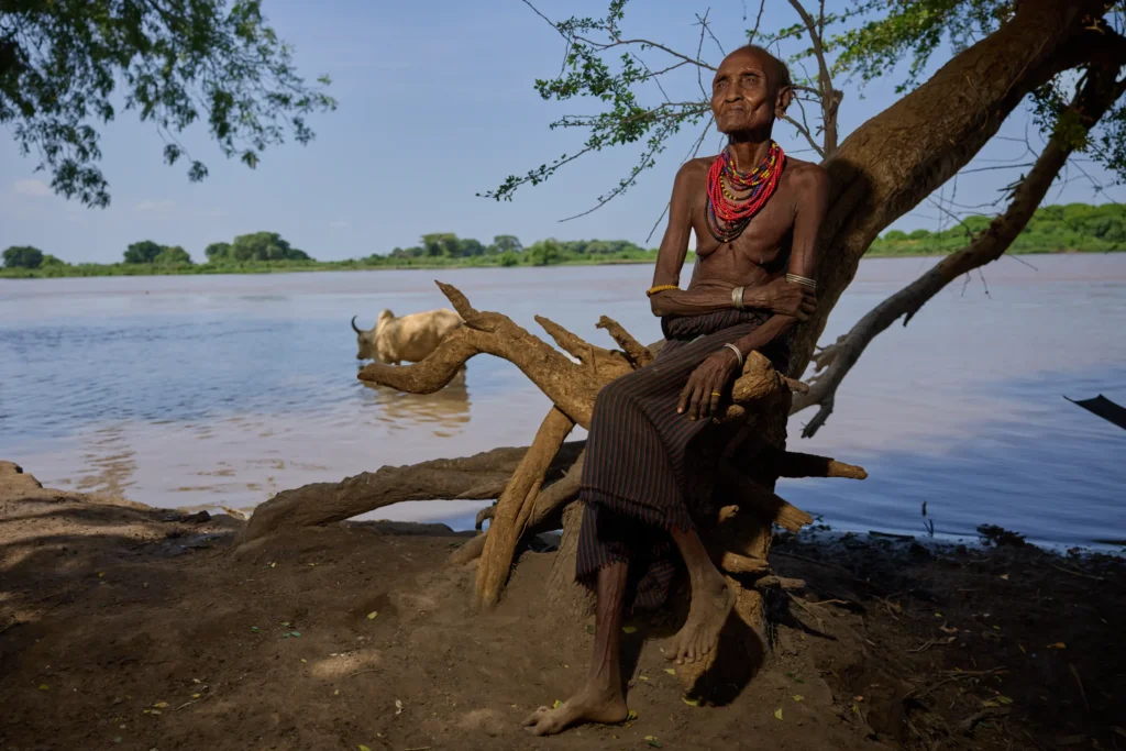 Dassanech woman relaxing by river under tree near tribal village, Ethiopia | Michaela Pupíková Photography