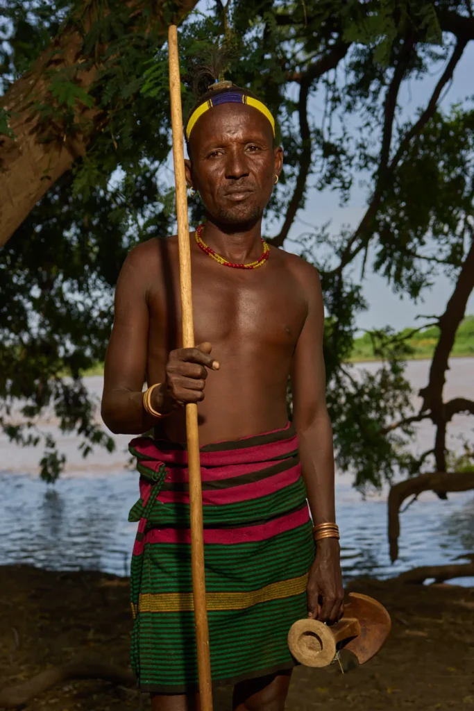 Dassanech man holding stick by Omo River near village in Ethiopia | Michaela Pupíková Photography