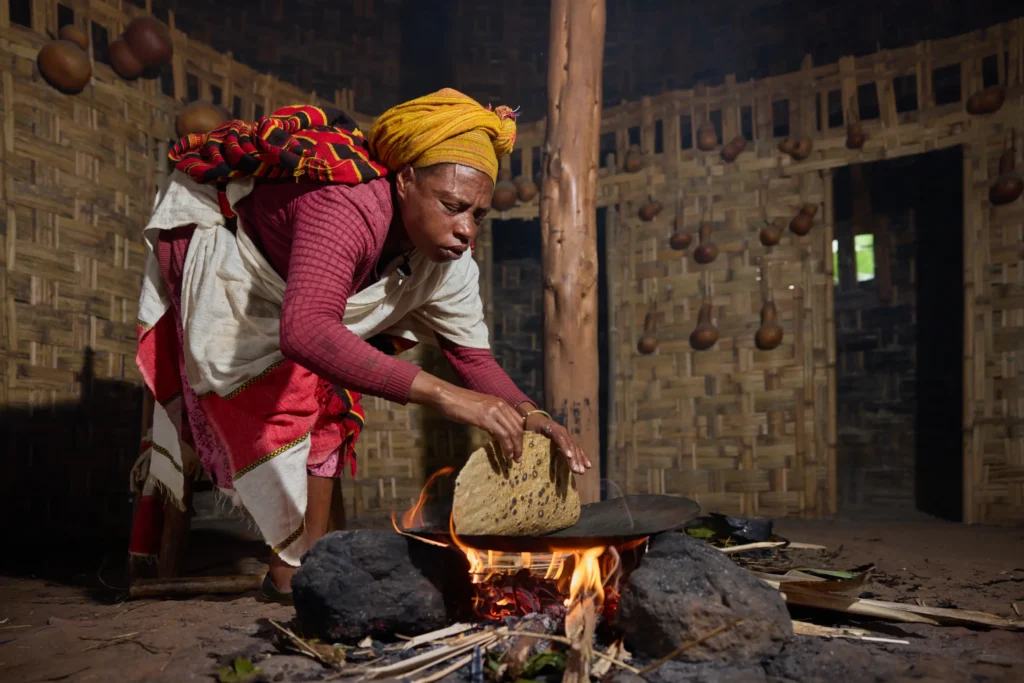 Shaping kocho flatbread on banana leaves in Dorze culinary ritual. Dorze village kitchen, Ethiopia | Michaela Pupíková Photography