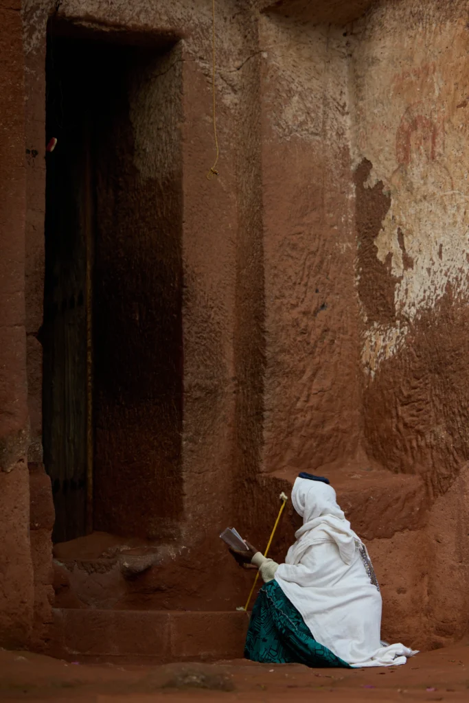 Pilgrim silhouette standing before narrow slit of light in stone corridor | Michaela Pupíková Photography
