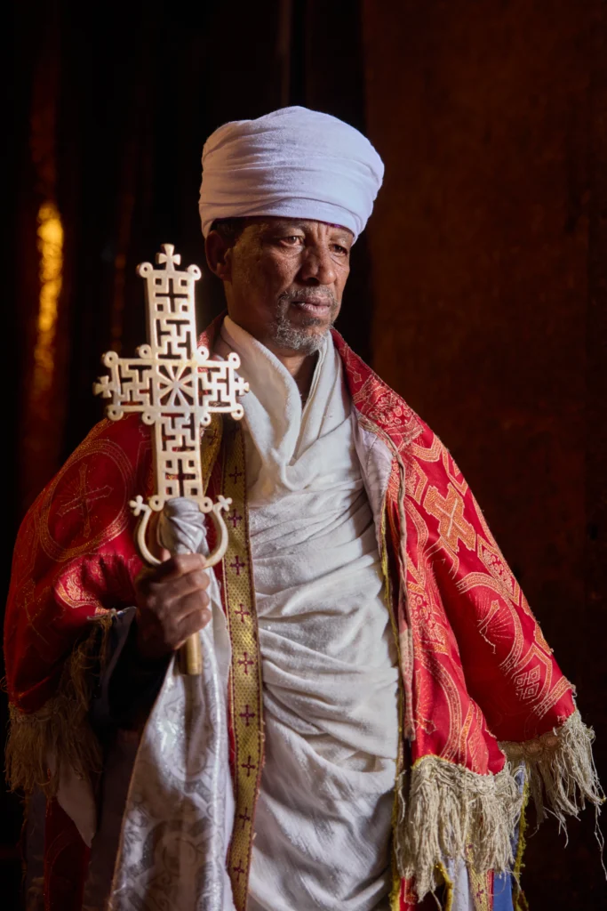 Side portrait of Ethiopian monk holding a traditional hand cross in Lalibela | Michaela Pupíková Photography