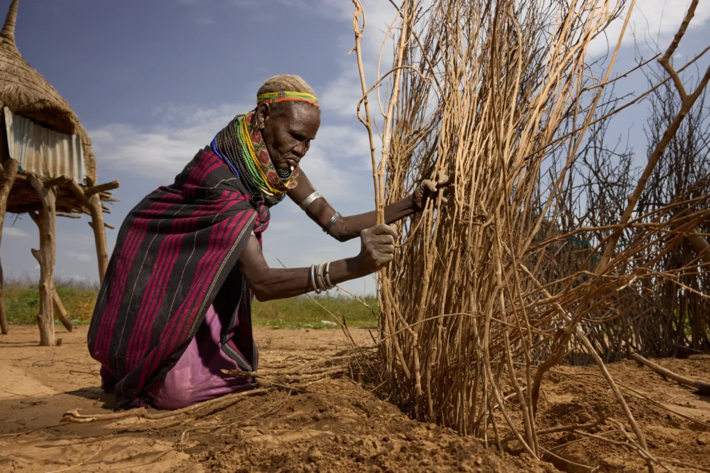 yangatom woman weaving or binding dry stalks for construction in Nyangatom village, Ethiopia | Michaela Pupíková Photography