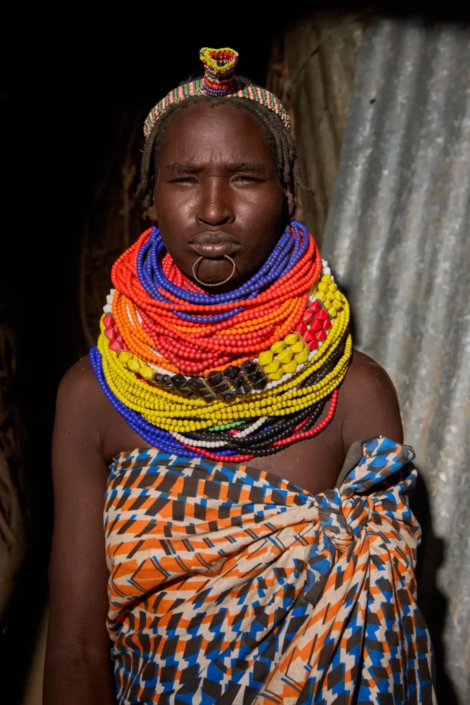 Nyangatom woman wearing multicolored bead necklaces and lip piercing in tribal Ethiopia | Michaela Pupíková Photography
